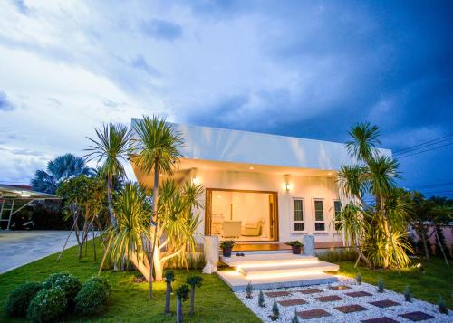 a house with palm trees in front of it at West View Villa in Kanchanaburi