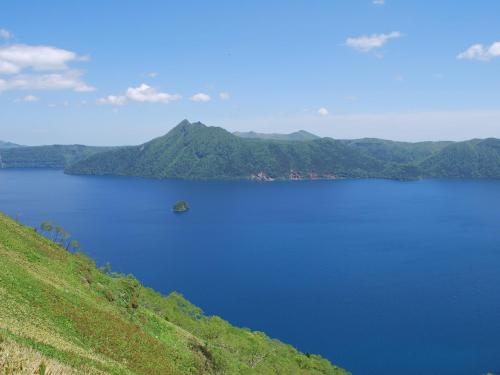 a large body of water with mountains in the background at Kussharo Prince Hotel in Teshikaga