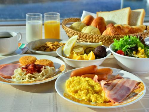 a table with plates of breakfast foods and drinks at Kussharo Prince Hotel in Teshikaga