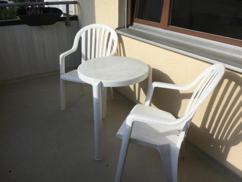 two white chairs and a white table and chairs at Disentis in Disentis