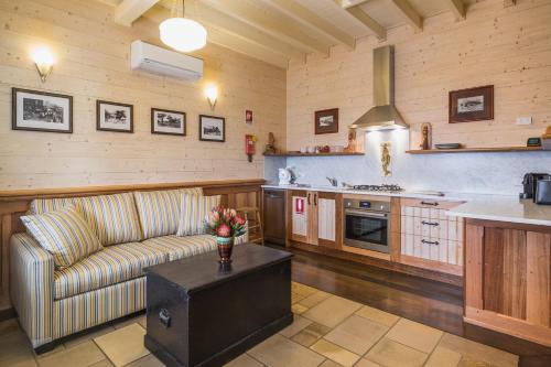 a living room with a couch and a kitchen at Old Bank Boutique Hotel in Mittagong