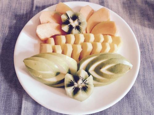 a white plate with sliced fruit on a table at Escalus Luxury Suites Verona in Verona