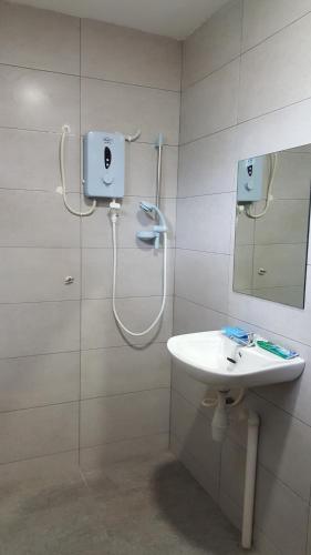 y baño con ducha, lavabo y espejo. en Ellis Lot 310, en Kuching