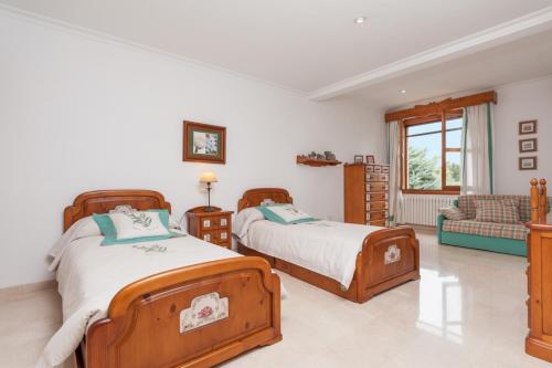 a bedroom with two beds and a couch at Can Gual in Inca