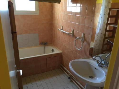 uma casa de banho com uma banheira e um lavatório e uma banheira em Les Bastidons em Sainte-Maxime