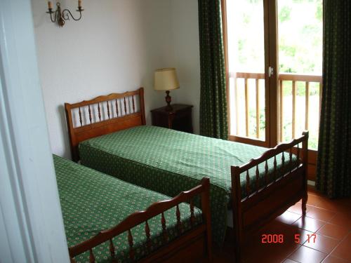 a bedroom with two twin beds and a window at Les Bastidons in Sainte-Maxime