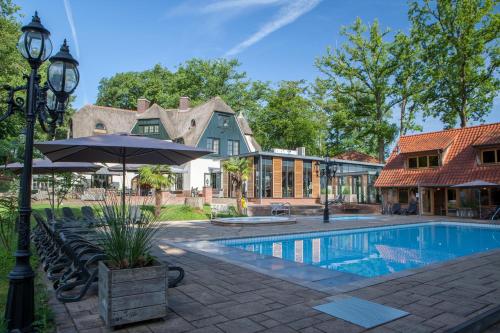 una casa con piscina e ombrellone di Huize Hölterhof Wellness Hotel Restaurant a Enschede