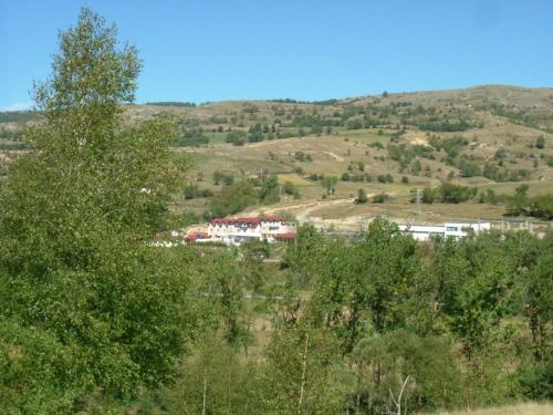 a building in the middle of a field with trees at Hotel Zenit Satovcha in Satovcha