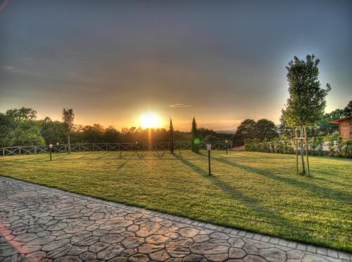 a park with the sun setting in the distance at Agriturismo Podere Del Lepre in San Quirico