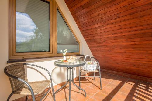 mały stół i krzesła na werandzie z oknami w obiekcie Apartament Owcze Runo Zakopane w Zakopanem
