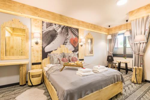 sypialnia z dużym łóżkiem z drewnianym zagłówkiem w obiekcie Apartament Owcze Runo Zakopane w Zakopanem