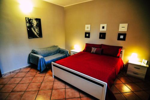 ピアッツァ・アルメリーナにあるVilla Giuliaのベッドルーム(赤いベッド1台、椅子付)