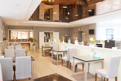 a restaurant with white chairs and tables and a counter at Jinjiang Inn Tianshui Chunfeng Road in Tianshui