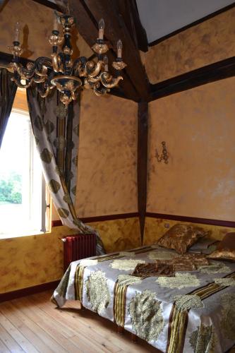 une chambre avec un lit et un lustre dans l'établissement Lit en Loire, à Saint-Cyr-sur-Loire