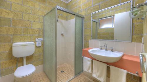a bathroom with a toilet and a sink and a shower at Yarra Holiday Park in Stuarts Point