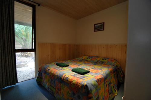 Кровать или кровати в номере Mallacoota Log cabins