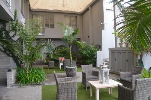 an outdoor patio with chairs and tables and plants at Be-Still Accommodation in Swakopmund