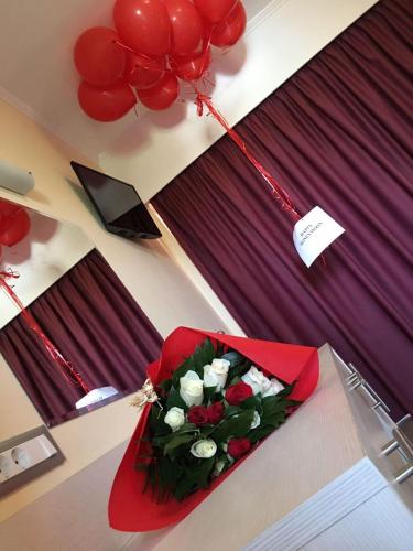 a bouquet of flowers on a table with balloons at Hotel Kalithea in Kallithea Rhodes
