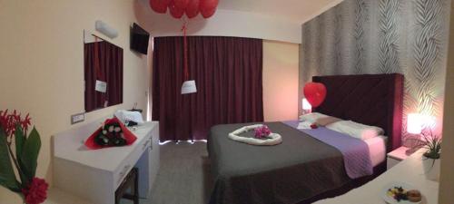a bedroom with a bed and a desk with a balloon at Hotel Kalithea in Kallithea Rhodes