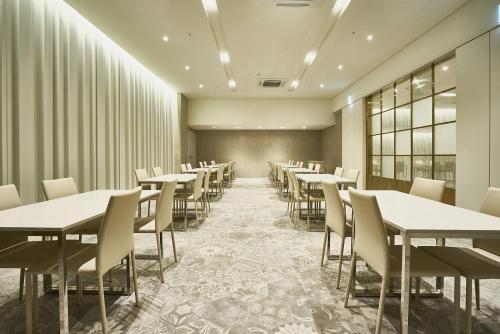 an empty dining room with tables and chairs at Royal Emporium Incheon Airport in Incheon