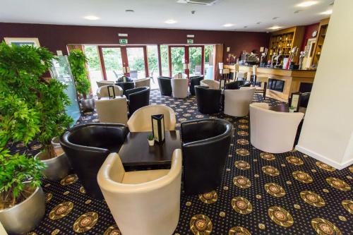 a bar with a bunch of chairs in a room at Padbrook Park Hotel in Cullompton