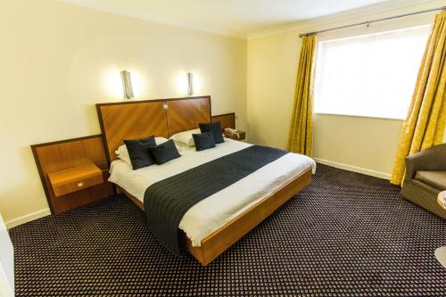 a hotel room with a large bed and a window at Padbrook Park Hotel in Cullompton