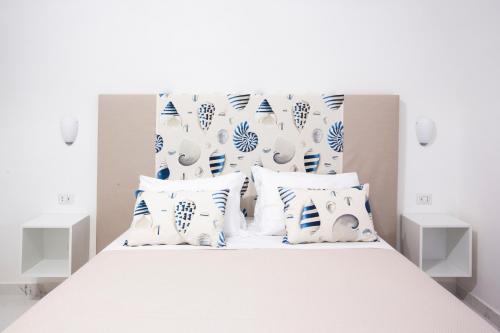 a bedroom with a white bed with blue and white pillows at Holiday Sorrento Center in Sorrento