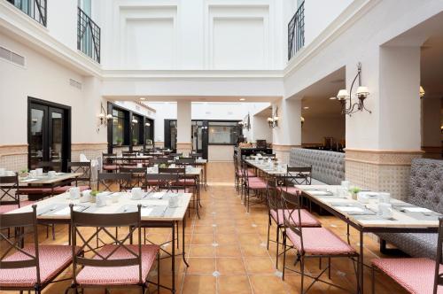 a dining room filled with tables and chairs at Eurostars Regina in Seville