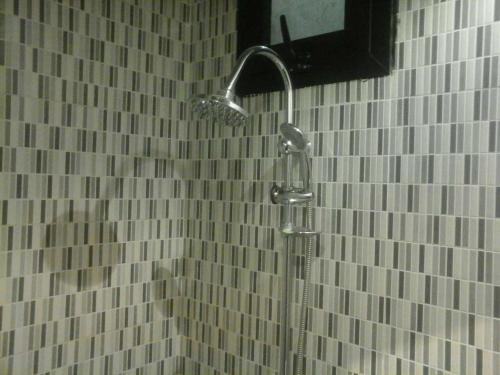 a shower in a bathroom with white tiled walls at Appartement à Natangue 1 in Saly Portudal