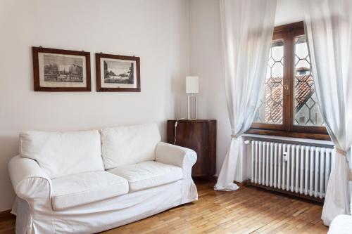 a white couch in a living room with a window at Palazzo Valmarana Braga in Vicenza