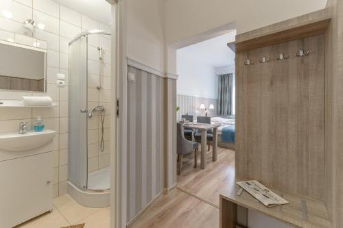 a bathroom with a shower and a sink and a toilet at Sanatorium Uzdrowiskowe Chemik in Duszniki Zdrój