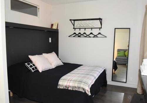 a bedroom with a black bed and a mirror at Barcelo Appart'hotel in Barcelonnette