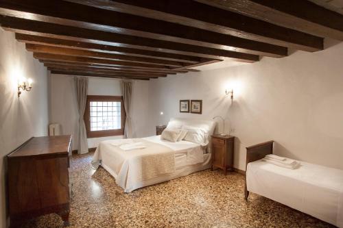 a bedroom with two beds and a wooden ceiling at Palazzo Valmarana Braga in Vicenza