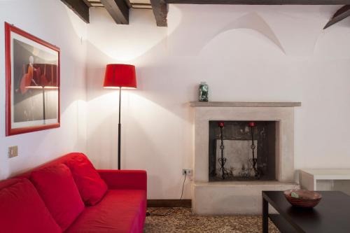 a living room with a red couch and a fireplace at Palazzo Valmarana Braga in Vicenza