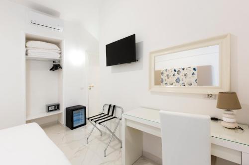 a white room with a desk and a tv at Holiday Sorrento Center in Sorrento
