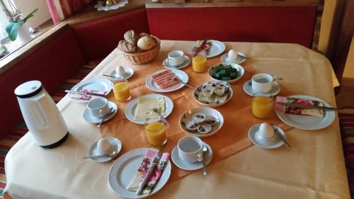 een tafel met borden en bekers voedsel erop bij Gästehaus Marianne Baier in Zederhaus
