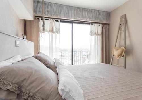 une chambre avec un lit avec une grande fenêtre dans l'établissement La maison de lulu, à Nice