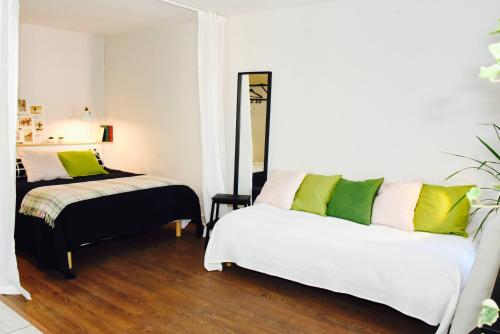 a bedroom with two beds with green pillows at Barcelo Appart'hotel in Barcelonnette