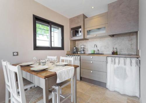 - une cuisine avec une table, des chaises et un évier dans l'établissement La maison de lulu, à Nice