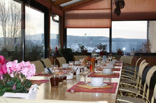 - une salle à manger avec une grande table fleurie dans l'établissement Les Hauts du Lac, à Gérardmer