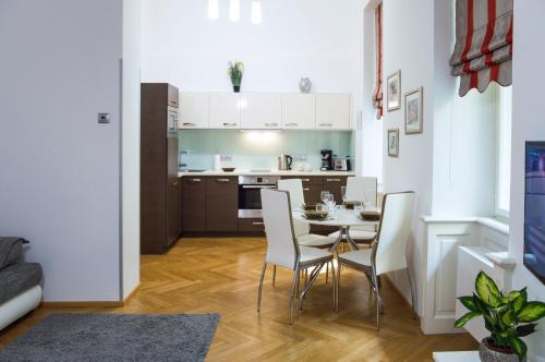 eine Küche und ein Esszimmer mit einem Tisch und Stühlen in der Unterkunft Modern Apartment Všehrdova in Prag