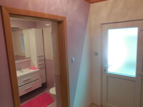 y baño con lavabo y espejo. en Apartmaji in Sobe Cuder, en Soča