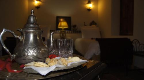 a table with a tea kettle and glasses on it at Riad Les Trois Palmiers El Bacha in Marrakech
