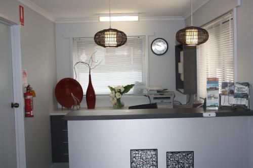 a kitchen with two pendant lights and a counter at Raglan Motor Inn in Warrnambool