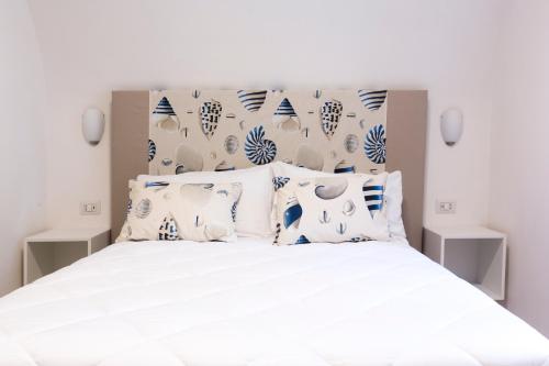 a bedroom with a white bed with blue and white pillows at Holiday Sorrento Center in Sorrento
