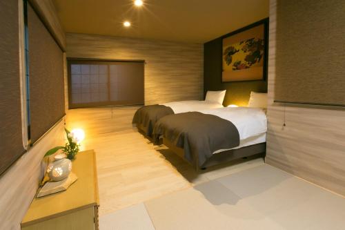 um quarto de hotel com duas camas e uma secretária e um quarto em Hosta Toji San em Quioto