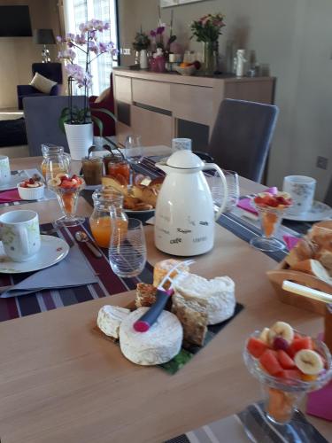 a table with a breakfast of bread and fruit at Ome sweet home in Laubressel