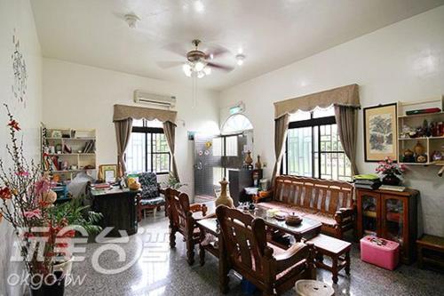 uma sala de estar com mesa e cadeiras em Reny Lake Warm Hostel em Fanlu