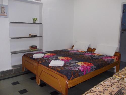 a small bedroom with a bed with flowers on it at Raj Mahal Guest House in Būndi