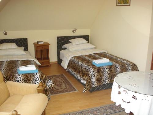 ein Wohnzimmer mit 2 Betten und einem Tisch in der Unterkunft Szent György Fogadó in Pécs